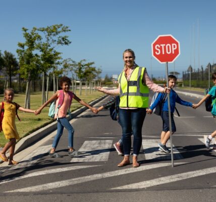 smiling crossing guard helping children cross the 2026 08 20 20 39 35 utc