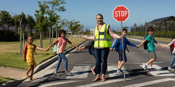 smiling crossing guard helping children cross the 2026 08 20 20 39 35 utc