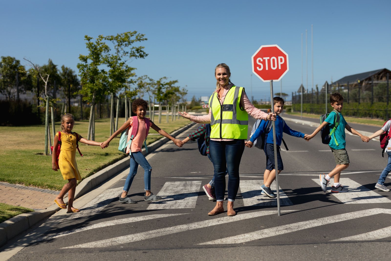 smiling crossing guard helping children cross the 2026 08 20 20 39 35 utc